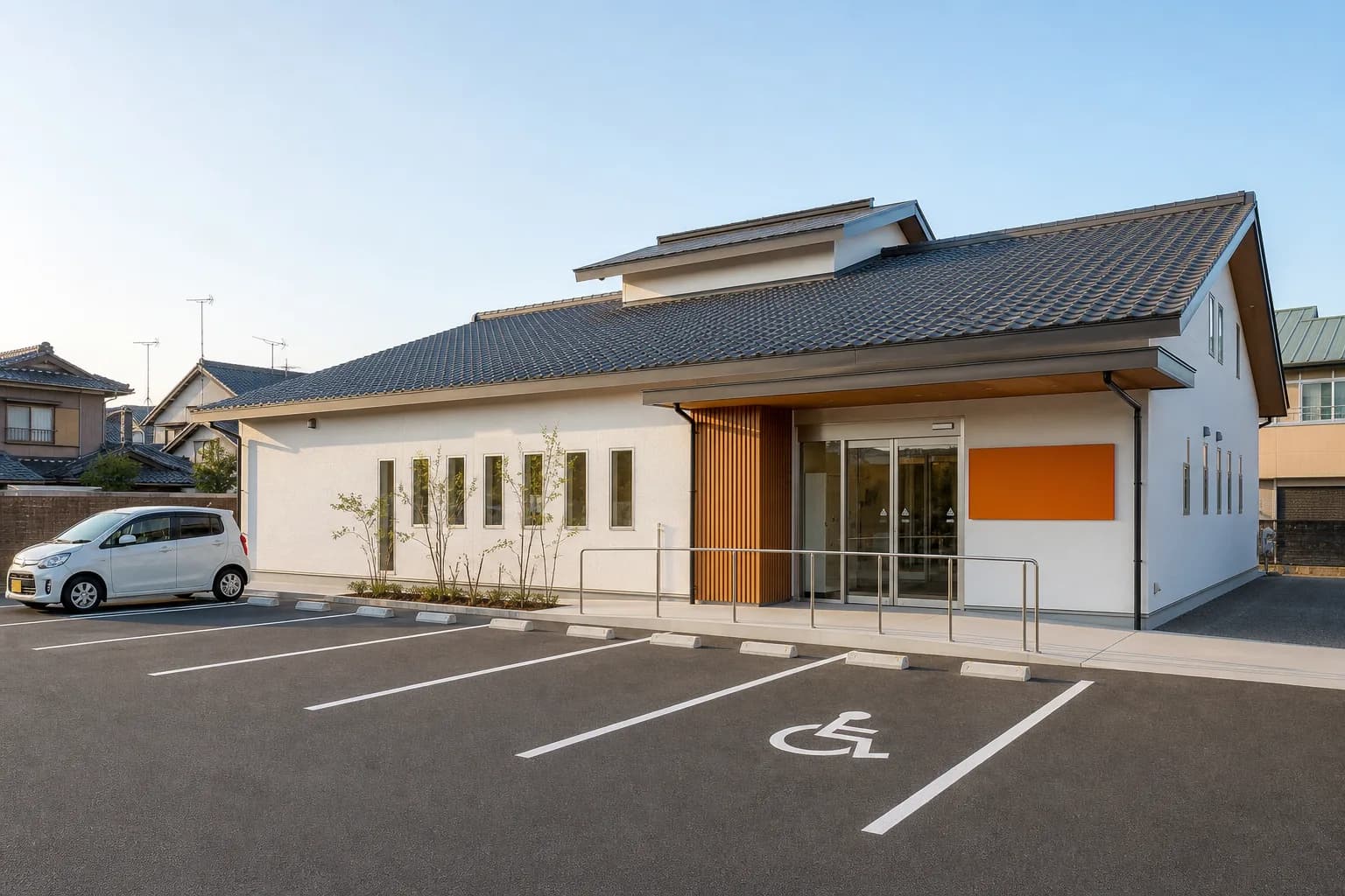 敷地内駐車場7台と段差のないバリアフリー入口を備えた、おかもと歯科・矯正歯科の外観